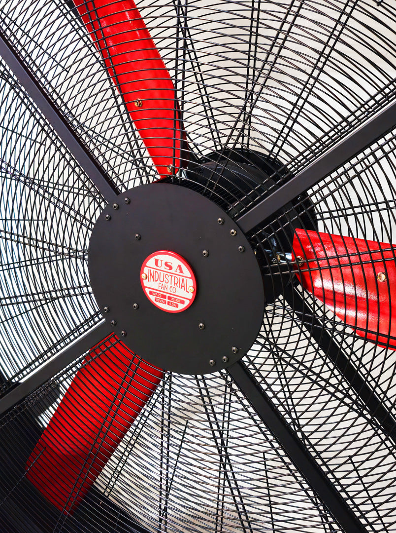 Close up of a metal frame for a 72" Floor Fan with black motor housing, red blades and red and white branded badge, product of Industrial Fan Co