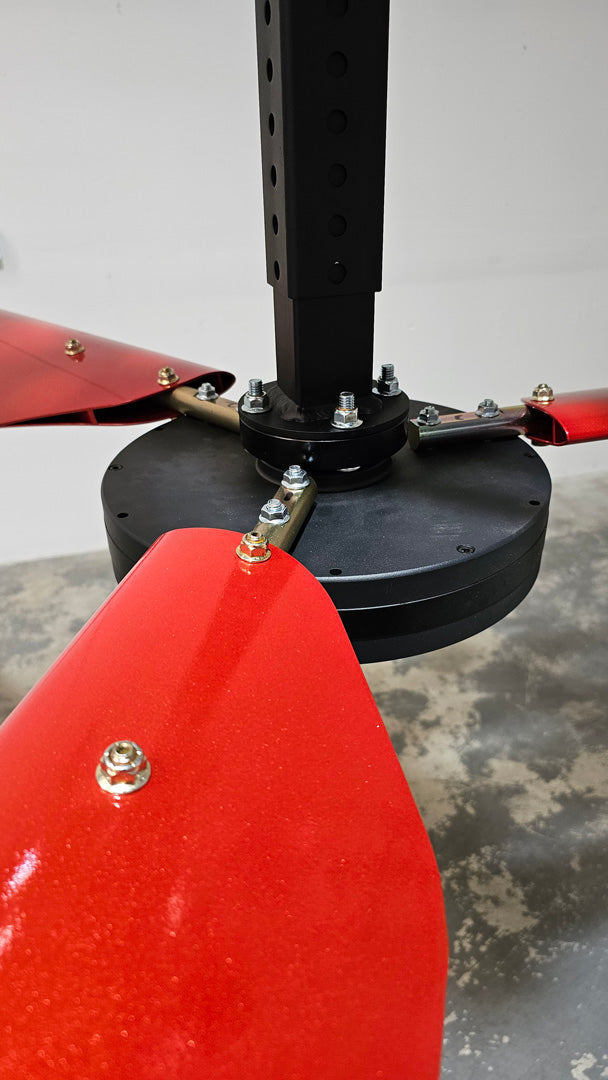 Close up of a telescoping mount, motor, hardware and 3 blades for DF3 Red Industrial Ceiling Fan from Industrial Fan Co, mounted on the ceiling with a gray floor underneath