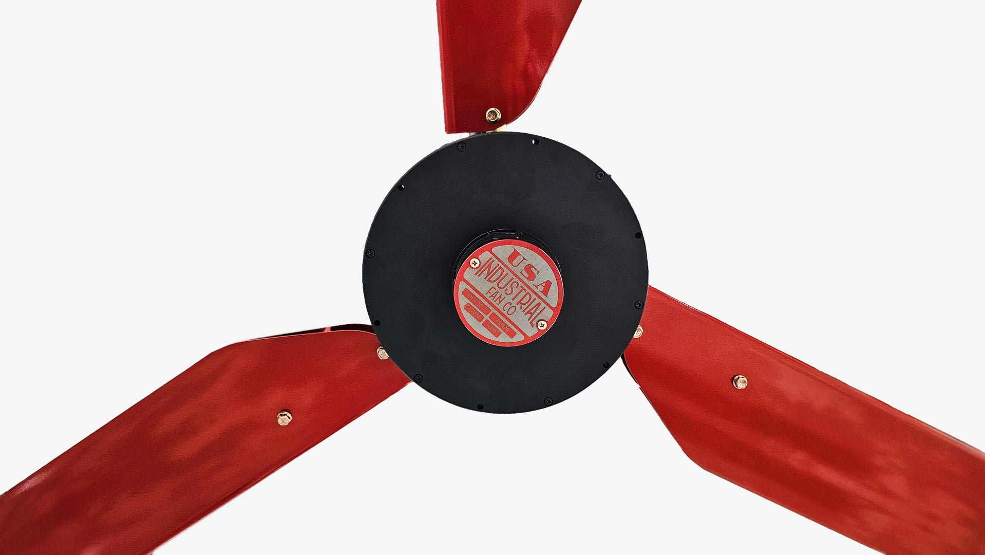 Close up of a motor casing, red and silver brand badge and 3 red blades for DF3 Red Industrial Ceiling Fan, product of Industrial Fan Co, on a white background