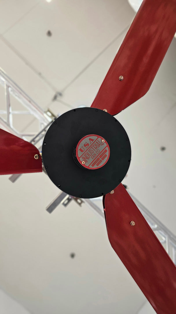Close up of a motor casing, red and silver brand badge and 3 blades for DF3 Red Industrial Ceiling Fan from Industrial Fan Co, mounted on the ceiling