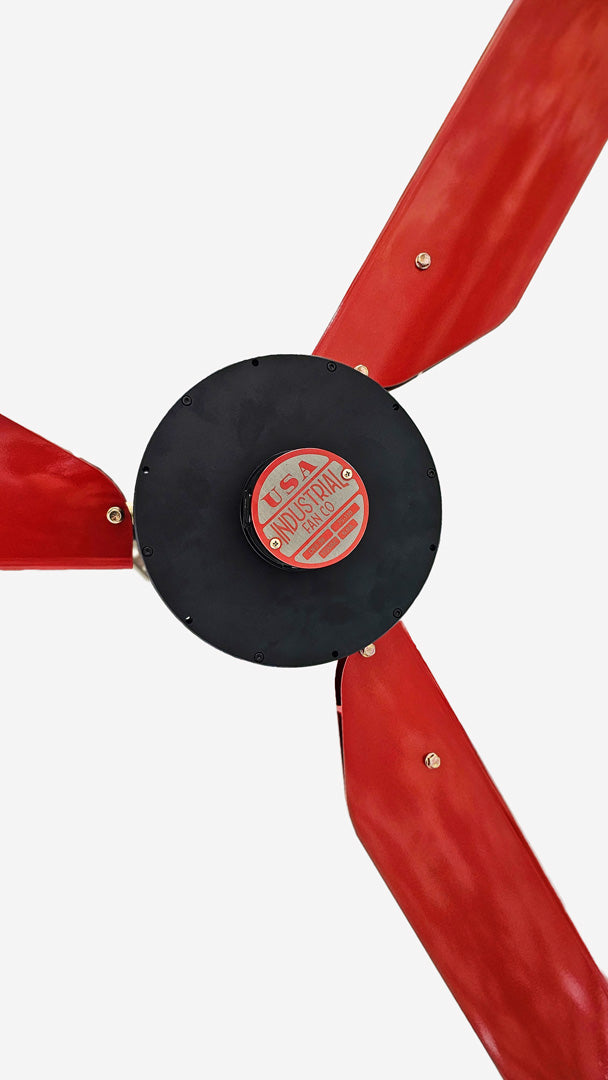 Close up of a motor casing, red and silver brand badge and 3 red blades for DF3 Red Industrial Ceiling Fan, product of Industrial Fan Co, on a white background