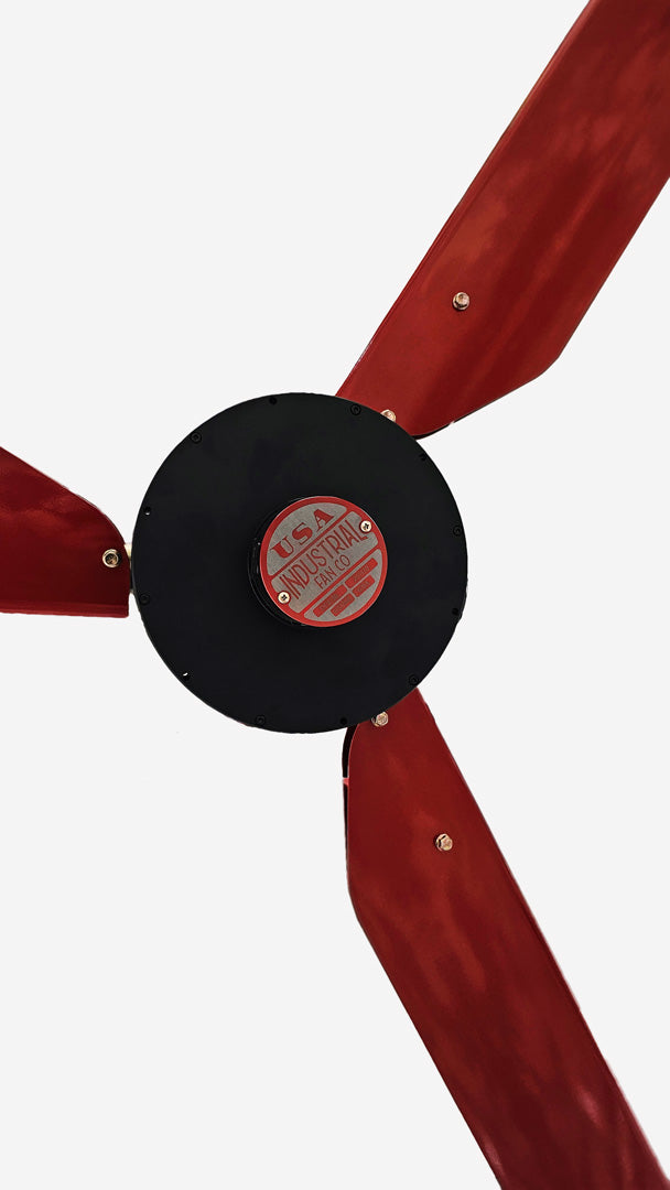 Close up of a motor casing, red and silver brand badge and 3 red blades for DF3 Red Industrial Ceiling Fan, product of Industrial Fan Co, on a white background