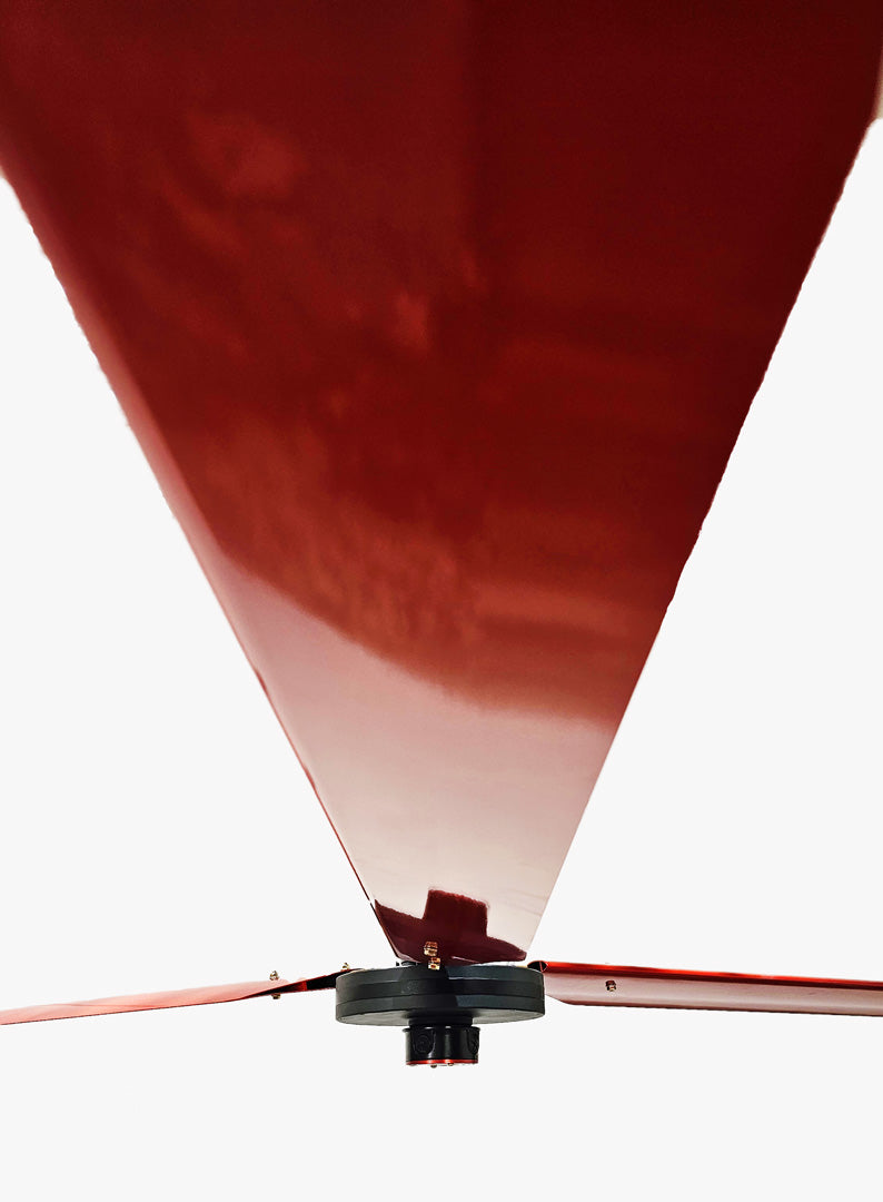 Close up of a one of the red blades, with motor and red brand badge in a distance,   for DF3 Red Industrial Ceiling Fan, product of Industrial Fan Co