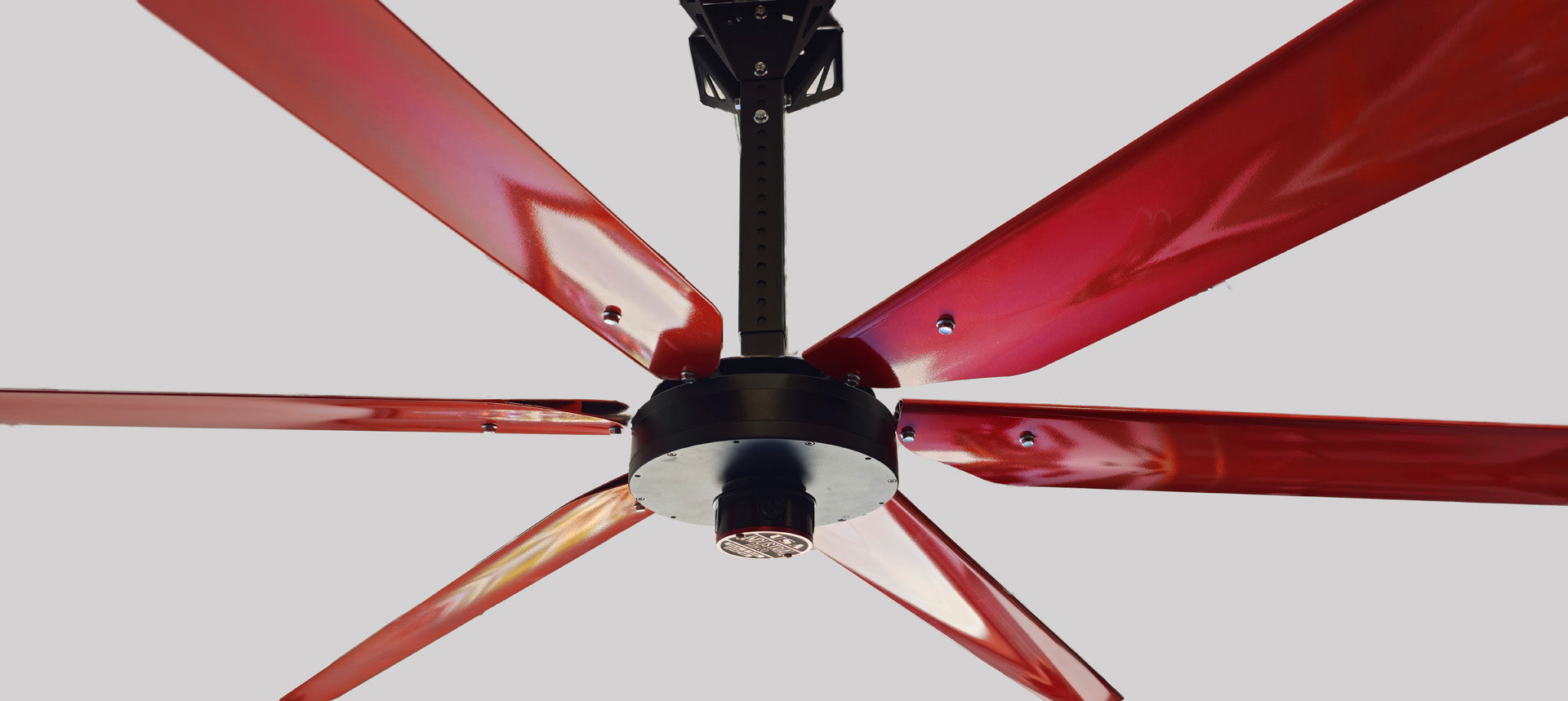 Close up of a telescoping wall mount, motor casing, red and silver brand badge and 6 red blades with silver hardware for DF6 Red Industrial Ceiling Fan, product of Industrial Fan Co