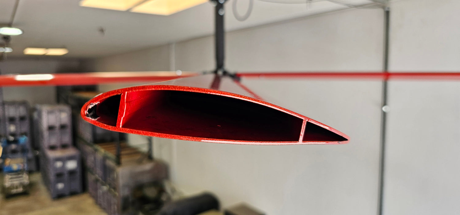 Close up of a telescoping mount, motor, and one of the blades for DF6 Red Industrial Ceiling Fan from Industrial Fan Co, mounted on the ceiling with a gray wall in the background