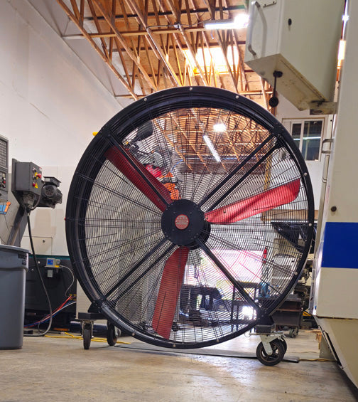72" Floor Fan with black housing, red blades, metal frame, black and silver casters and metal bearings, product of Industrial Fan Co, in a industrial hangar setting