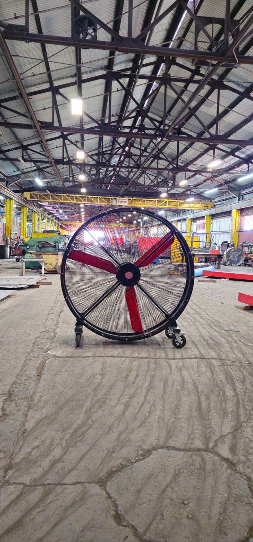 72" Floor Fan with black housing, red blades, metal frame, black and silver casters and metal bearings, product of Industrial Fan Co, in a industrial hangar