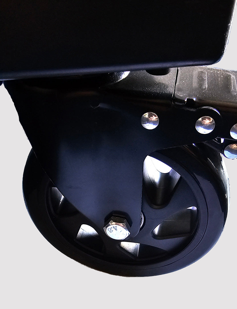 Close-up of a black wheel (caster) for 48" Floor Fan with metal bearings on a gray background, product of Industrial Fan Co