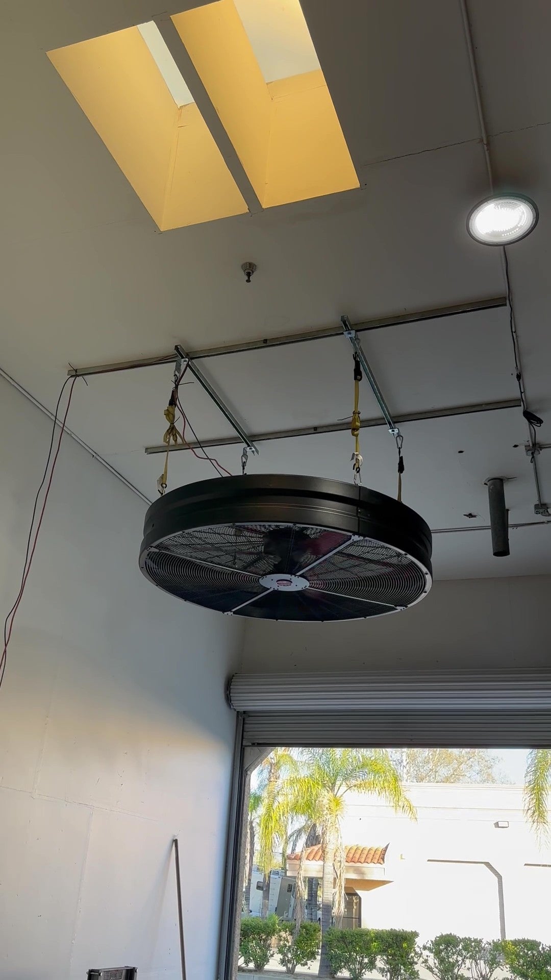WF72 Hanging Fan, product of Industrial Fan Co, hanging from the ceiling on yellow straps and working