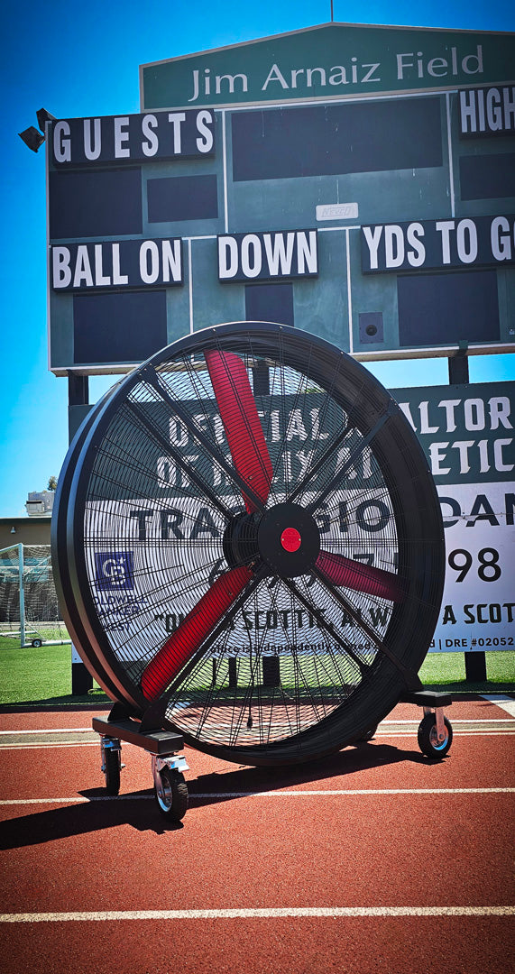 72" Floor Fan with black housing, red blades, metal frame, black and silver casters and metal bearings, product of Industrial Fan Co, on a track field of Jim Arnaiz Field