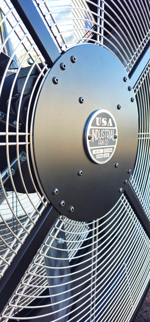 Close-up of a 48" industrial floor fan with silver blades and black housing on a white background with a visible brand logo, product of Industrial Fan Co large 