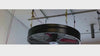 WF72 Hanging Fan, product of Industrial Fan Co, with black housing and red blades,  hanging from the ceiling on yellow straps and working
