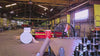 72" Floor Fan with black housing, red blades, metal frame, black and silver casters and metal bearings, product of Industrial Fan Co, in a industrial hangar